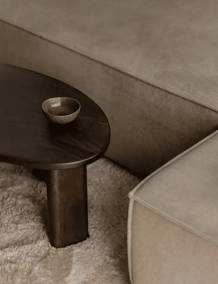 Cận cảnh bàn trà gỗ sẫm và sofa vải xám ấm