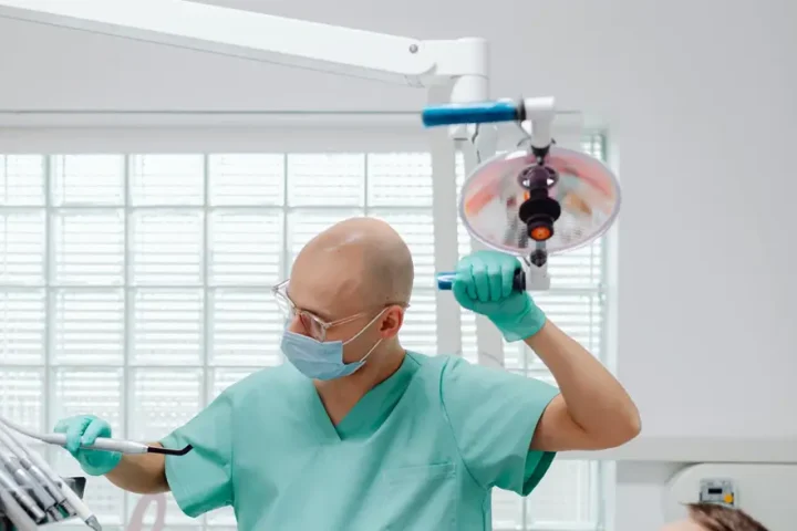 Bác sĩ chỉnh đèn chuẩn bị khám răng định kỳ