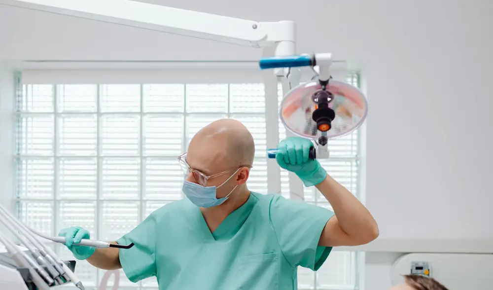 Bác sĩ chỉnh đèn chuẩn bị khám răng định kỳ