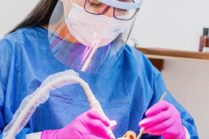 Bác sĩ chiếu đèn tẩy trắng răng cho khách
