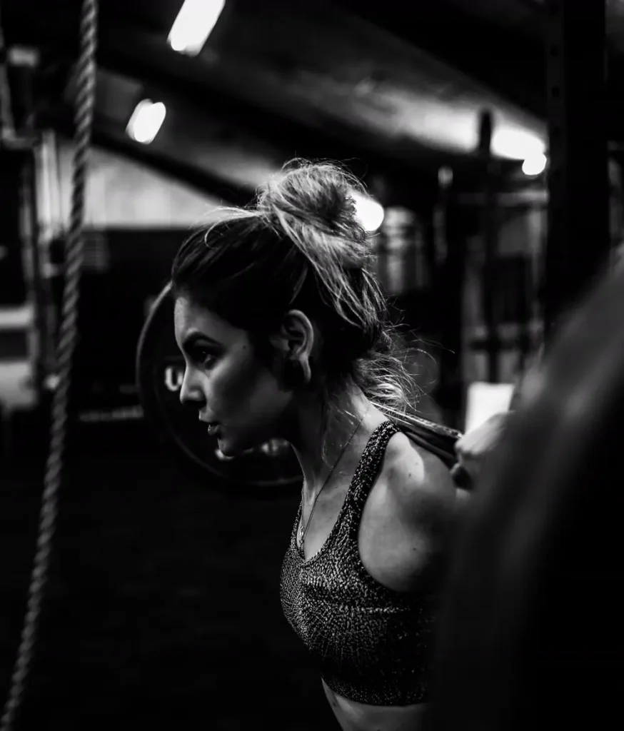 Ảnh đen trắng cô gái chuẩn bị gánh tạ trong phòng gym