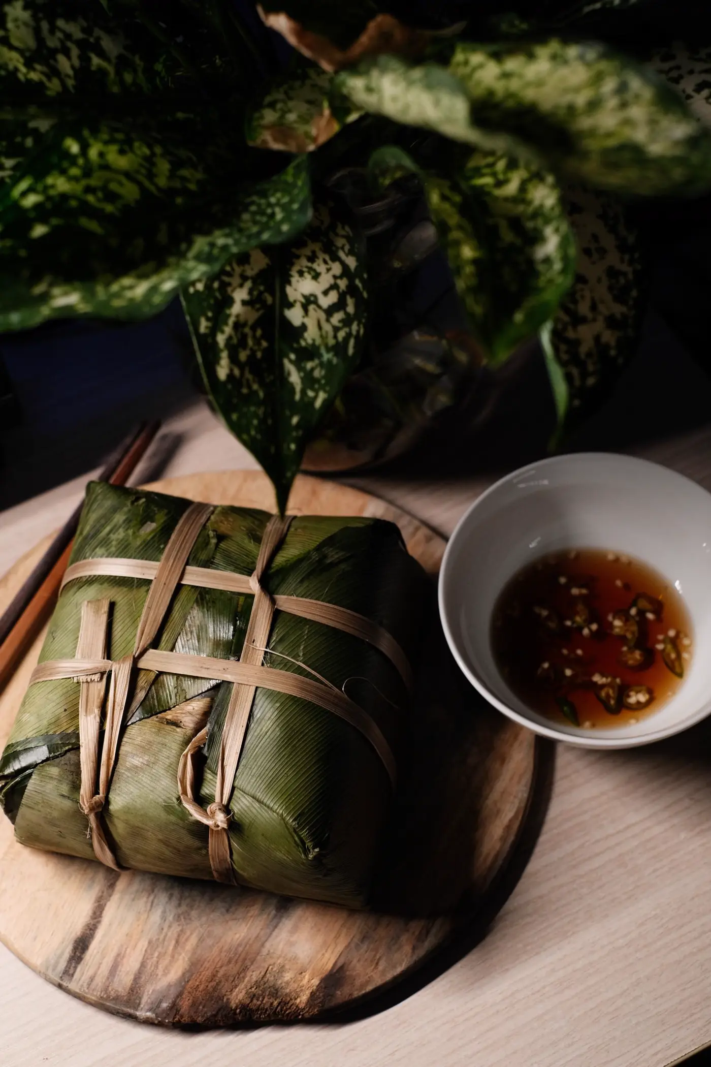 Bánh chưng cắt miếng trên đĩa gỗ kèm nước chấm