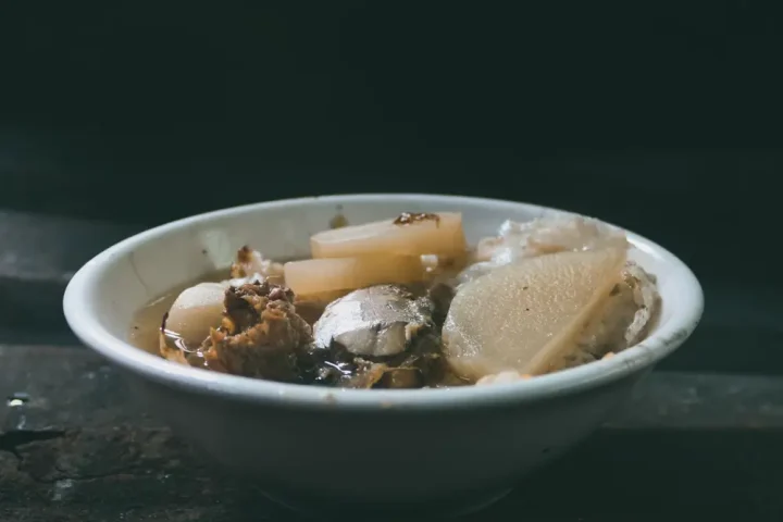 Bát canh nấm nóng trên bàn gỗ