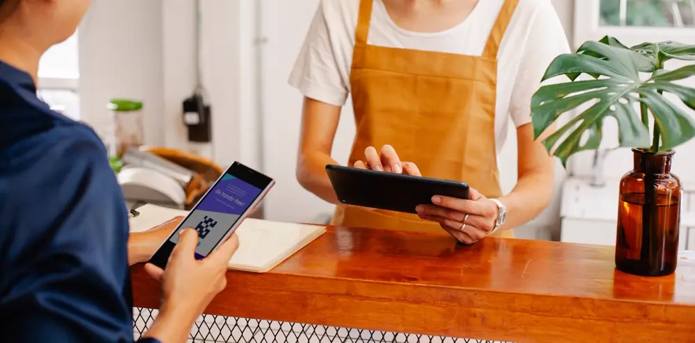Khách quét mã thanh toán bằng điện thoại tại quầy