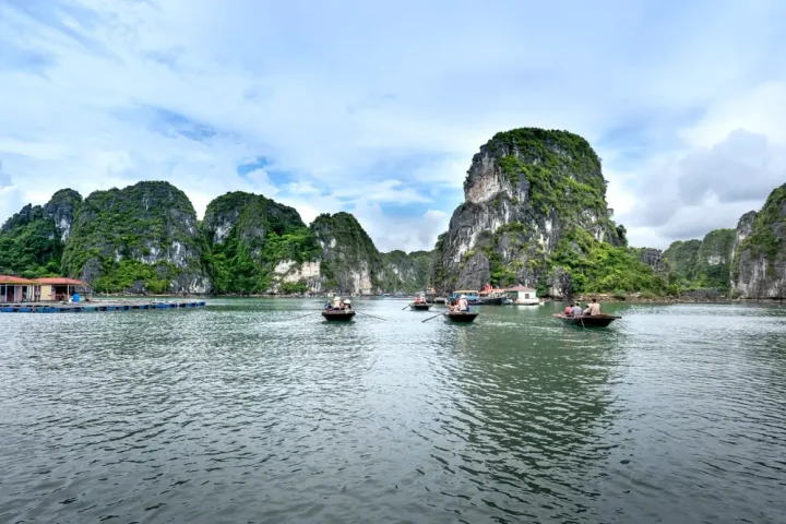 Thuyền đi giữa những khối núi đá trên vịnh