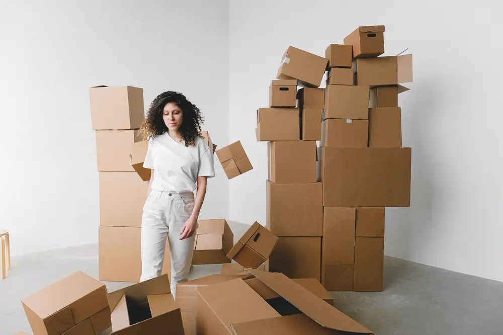 Cô gái đứng giữa những chồng thùng carton sau khi chuyển nhà