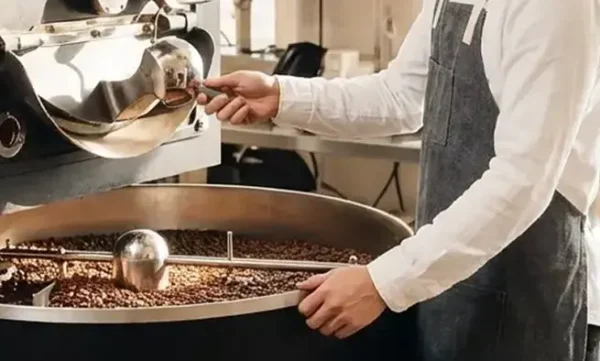 Thợ rang đảo hạt trong máy rang cà phê
