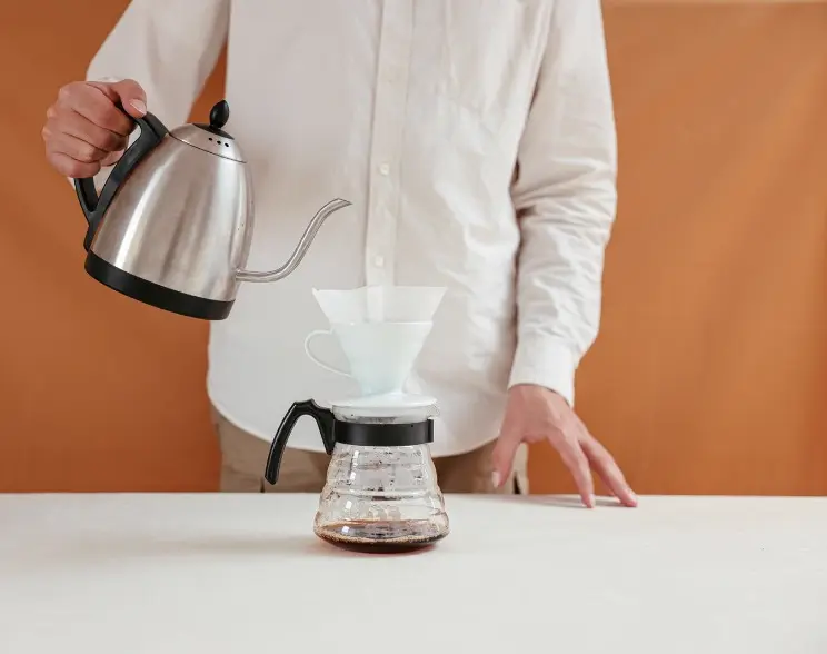 Rót nước nóng từ ấm cổ ngỗng vào phễu pha tay