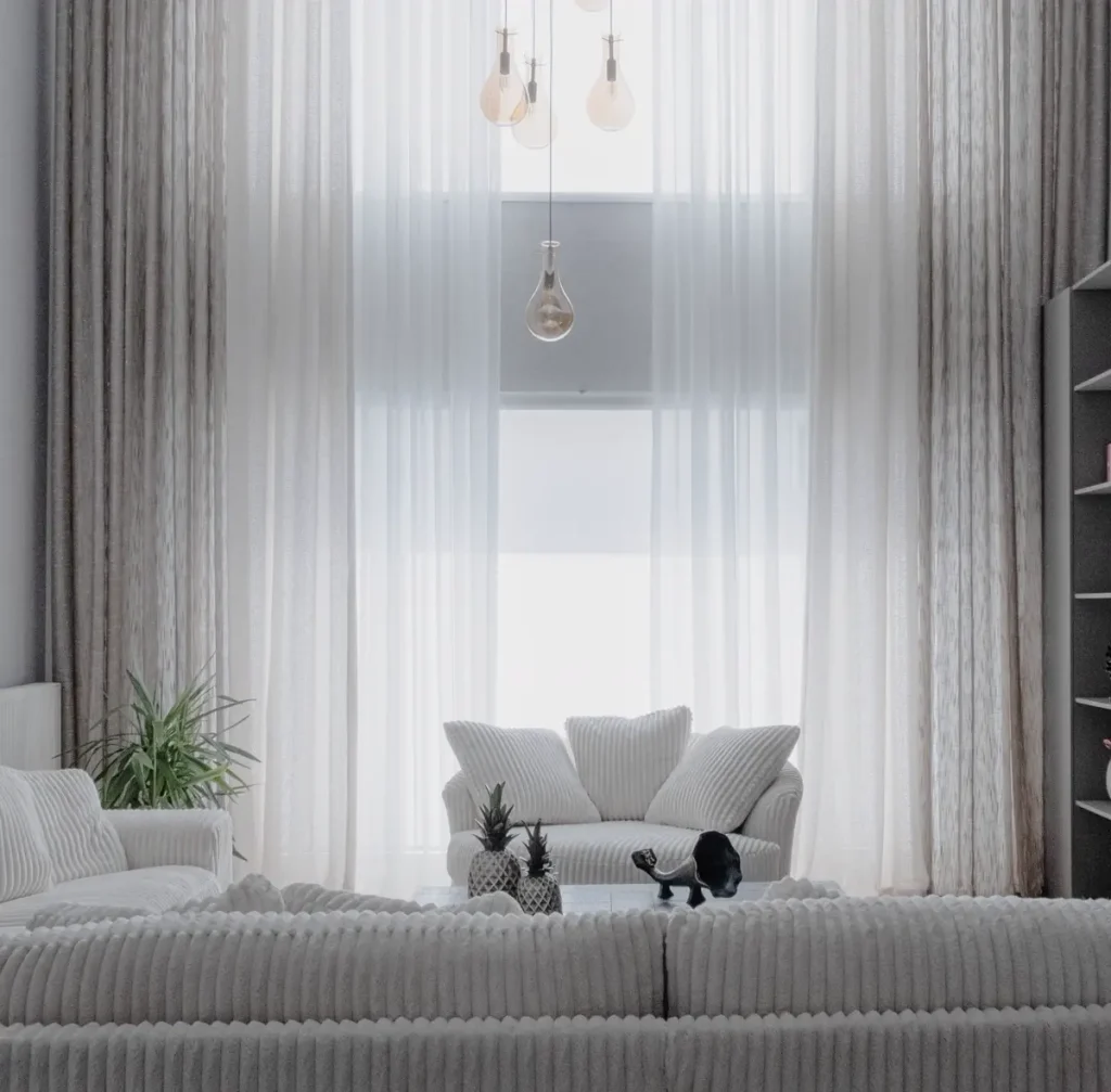 Phòng khách trắng, rèm voan cao kịch trần và sofa vải xám