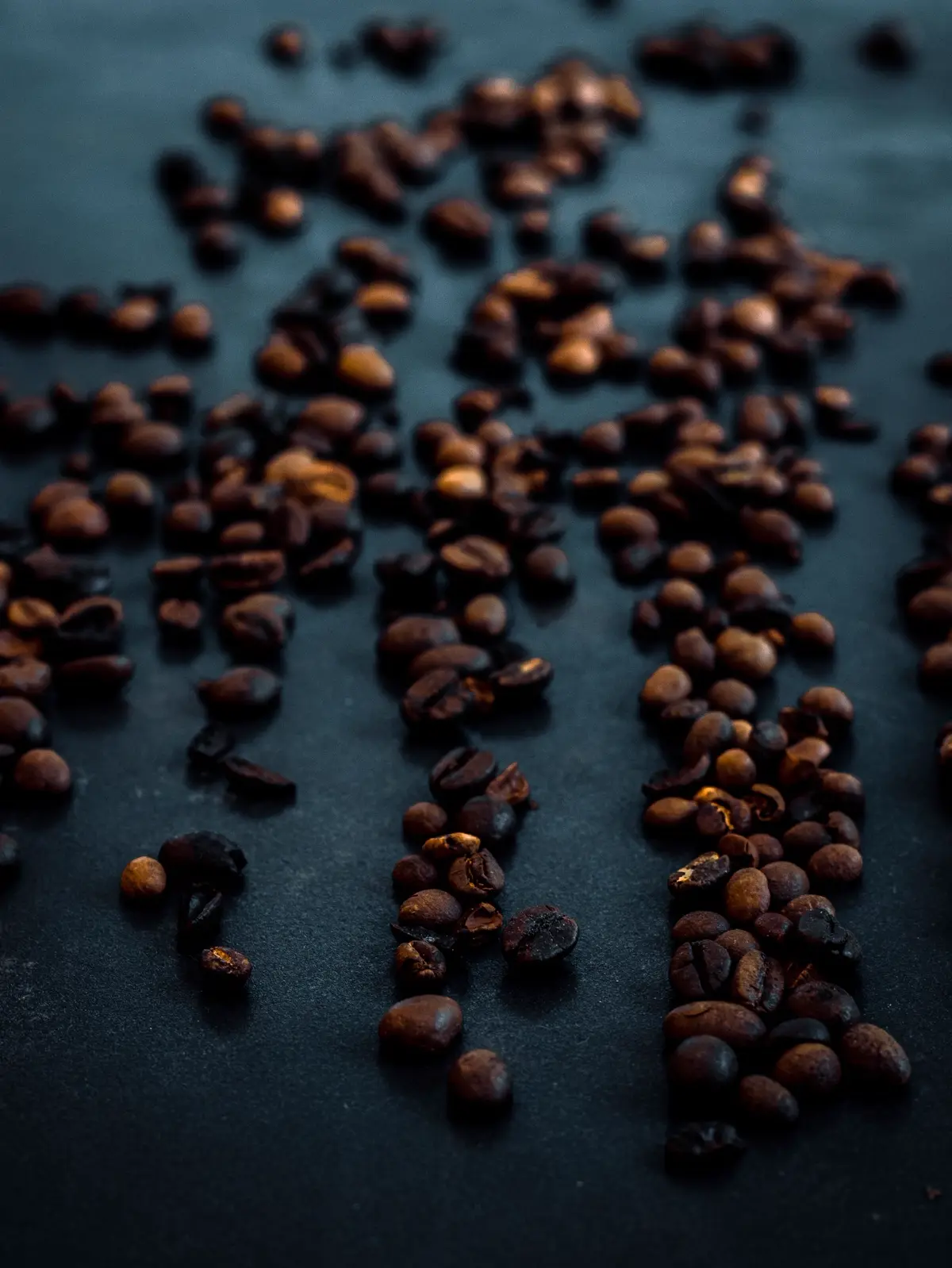Hạt cà phê Robusta rang sẫm rải trên bàn