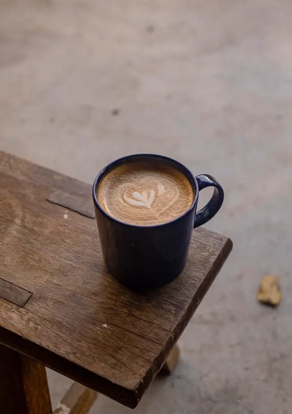 Cốc latte xanh đậm trên bàn gỗ