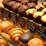 Muffin và croissant bày trong tủ bánh