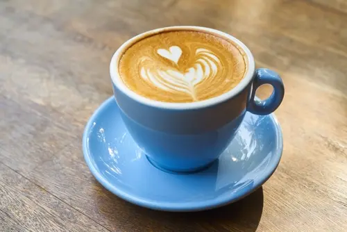 Ly latte hình trái tim trong tách xanh
