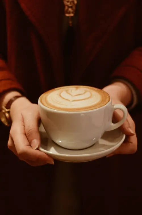 Hai tay nâng tách latte