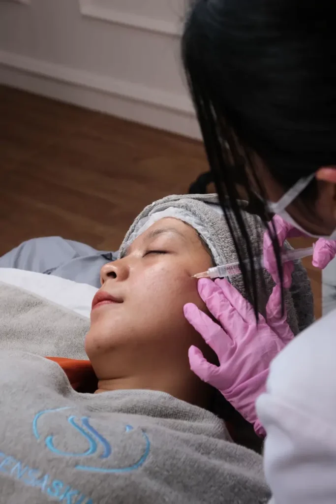 Chuyên viên Bảo Trân đeo găng làm da mặt cho khách