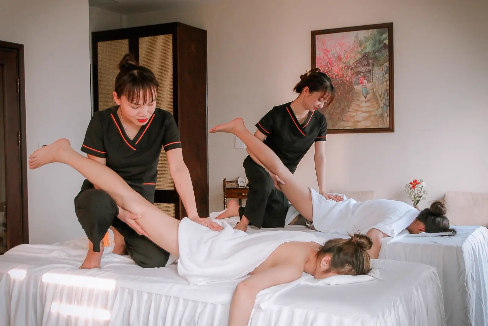 Hai chuyên viên massage cùng lúc cho hai khách