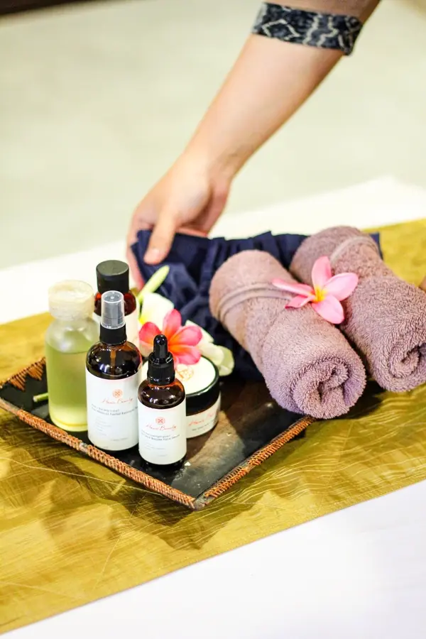 Khay tinh dầu, khăn cuộn và hoa đại cho buổi gội dưỡng sinh