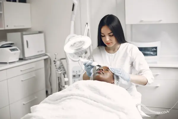 Chuyên viên làm trẻ hoá da mặt bằng máy cho khách