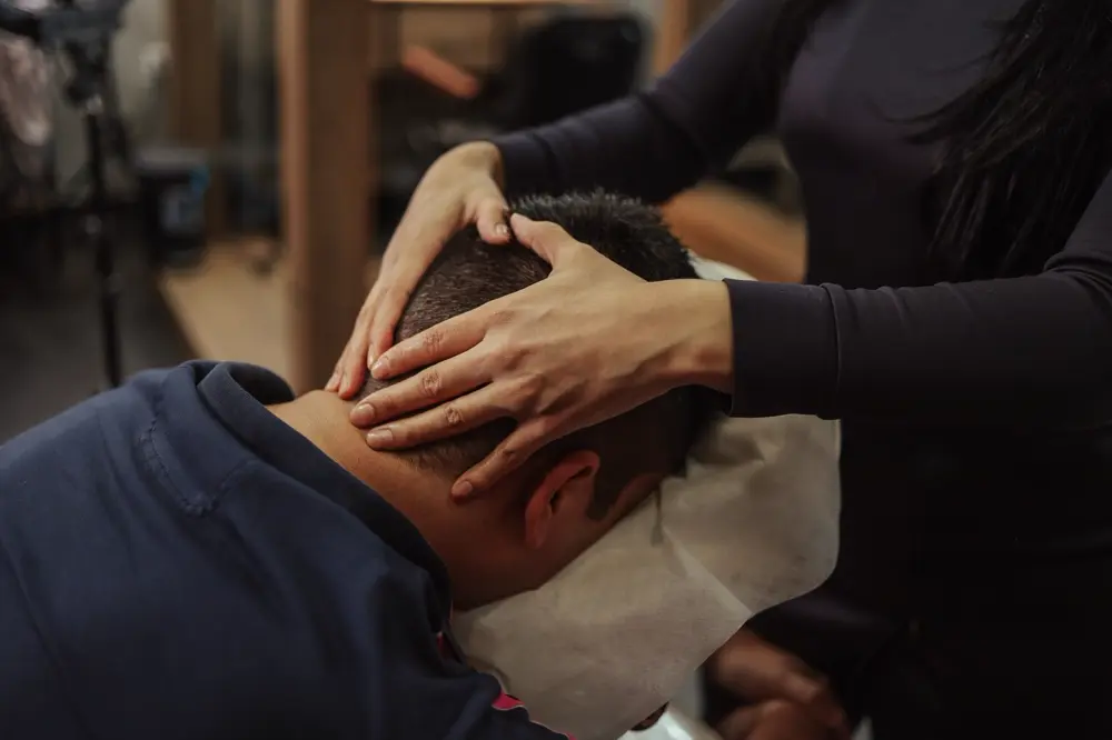 Chuyên viên massage đầu cho khách trước khi gội