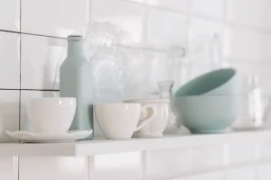 Bình cổ cao men ngọc cạnh tách và bát trắng