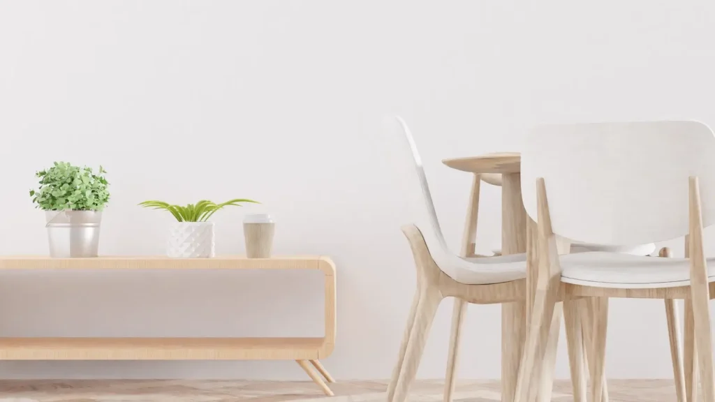 Góc ăn gỗ sáng màu với ghế trắng và chậu cây