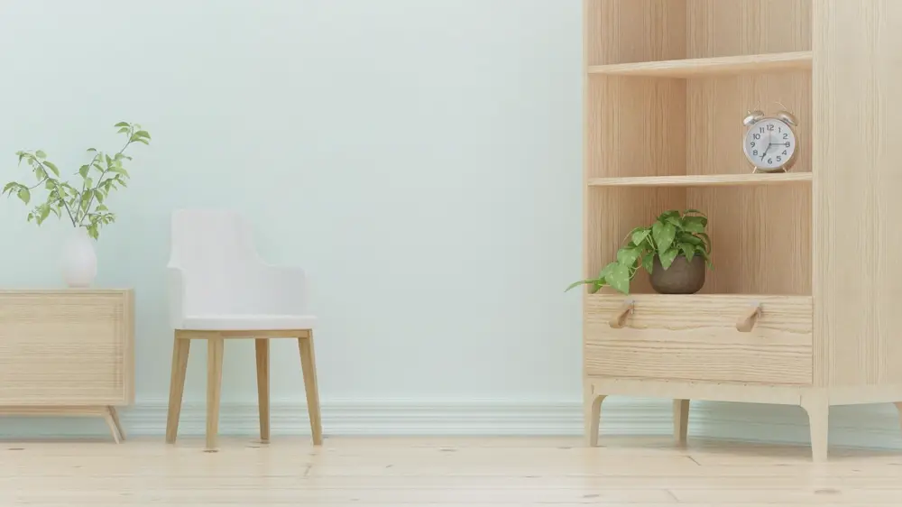 Kệ gỗ sáng màu, ghế và cây xanh trong phòng sáng