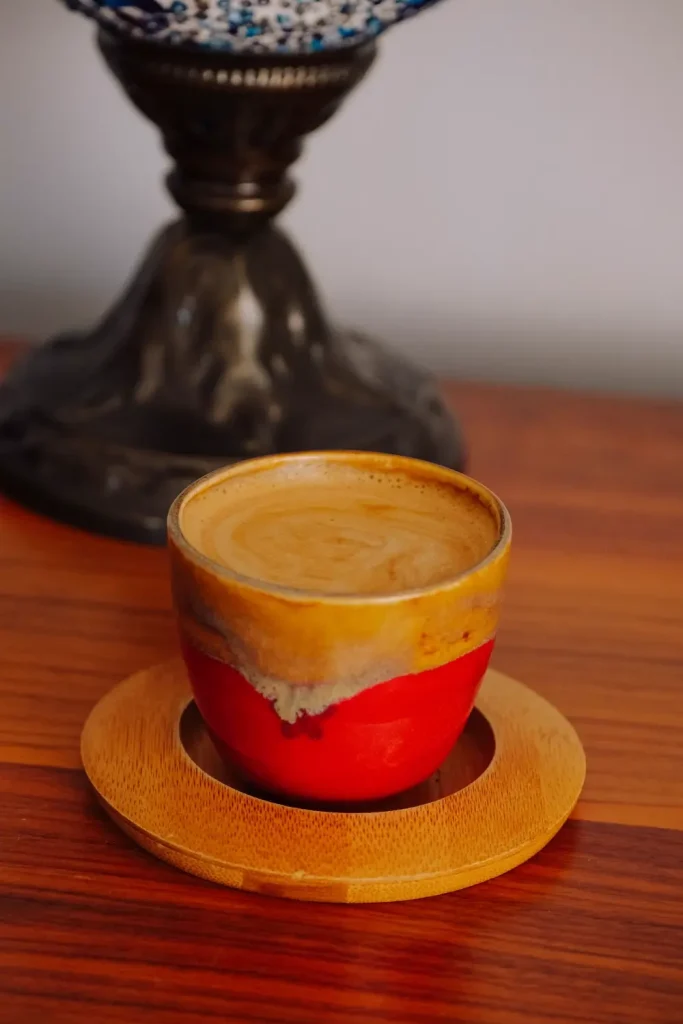 Tách cà phê đặc trên đĩa gốm đỏ