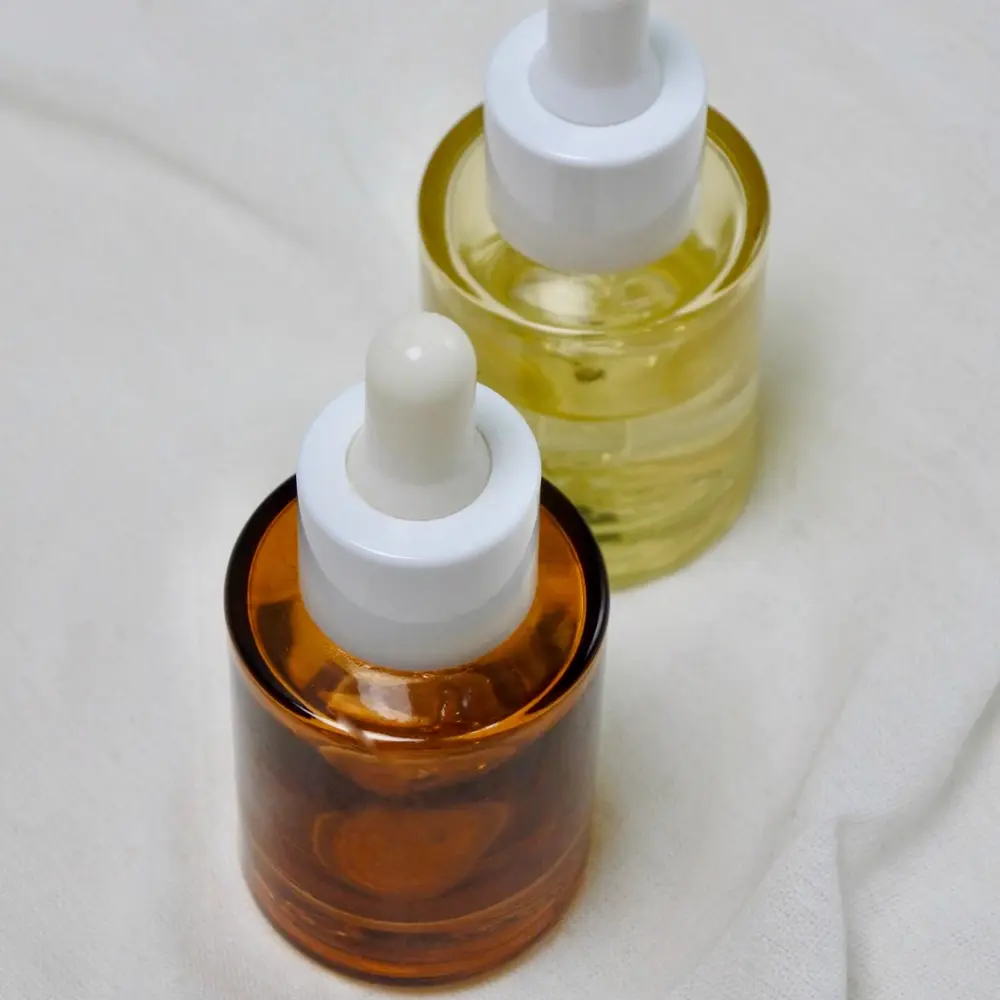 Hai lọ dầu dưỡng nhỏ giọt màu hổ phách
